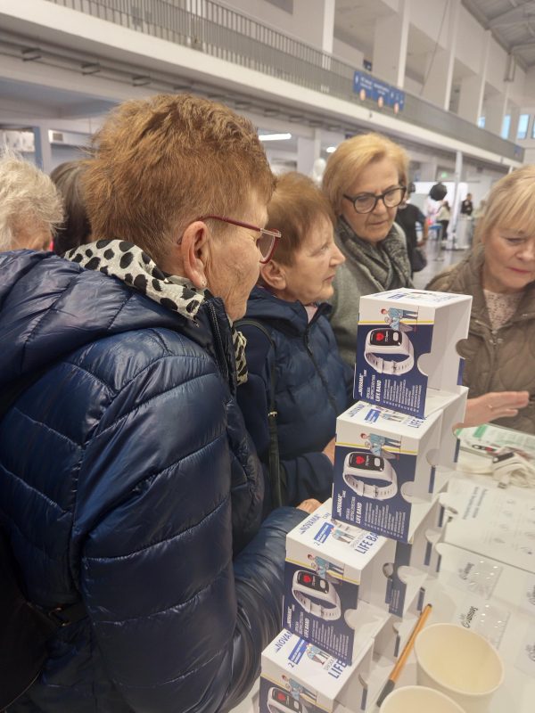 Ludzie przy stoisku z produktami - opaski bezpieczeństwa